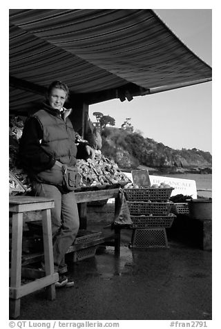 Oyster stand and vendor in Cancale. Brittany, France (black and white)