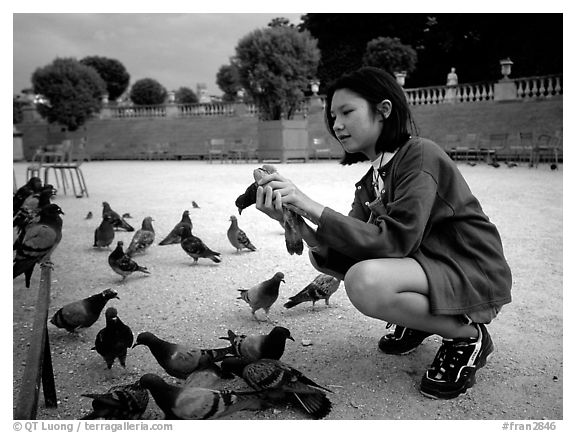 Girl feeding pigeon, Jardin du Luxembourg. Quartier Latin, Paris, France