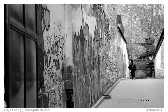 Boy in side alley with graffiti on walls. Paris, France (black and white)