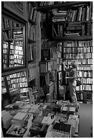 Picking-up a book in Shakespeare and Co bookstore. Quartier Latin, Paris, France ( black and white)