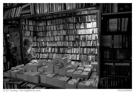 Checking a book in Shakespeare and Company bookstore. Quartier Latin, Paris, France