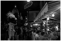 Outdoor dining at night on the Place du Tertre, Montmartre. Paris, France ( black and white)
