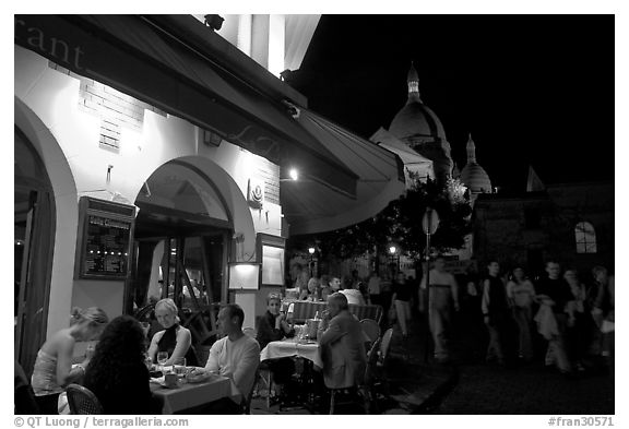 Outdoor restaurant at night on the Place du Tertre, Montmartre. Paris, France (black and white)