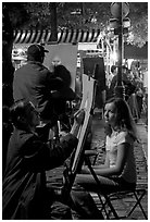 Artists drawing portraits at night on the Place du Tertre, Montmartre. Paris, France (black and white)