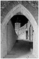 Ramparts and tower framed by gate at night. Carcassonne, France (black and white)