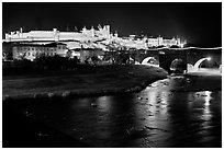 Fortified city and Pont Vieux crossing the Aude River by night. Carcassonne, France (black and white)
