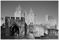 Main entrance of medieval city  with child and adult walking in. Carcassonne, France ( black and white)