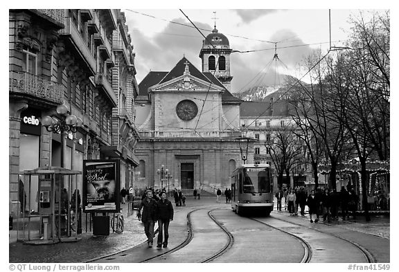 Street with people walking, tramway and church. Grenoble, France (black and white)