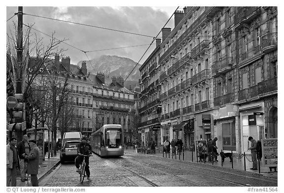 Bicyclist and tramway next to Victor Hugo place. Grenoble, France (black and white)