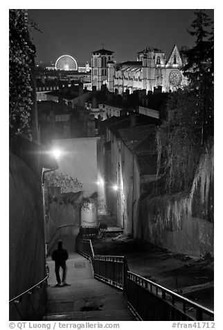 Man walking down stairs from Fourviere Hill, with St-Jean Cathedral below. Lyon, France (black and white)