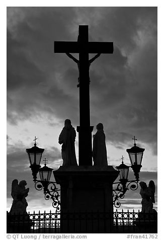 Cross and statues with sunset clouds. Avignon, Provence, France (black and white)