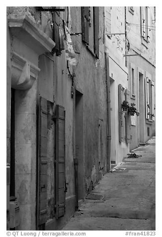 Painted facades in narrow street. Arles, Provence, France (black and white)