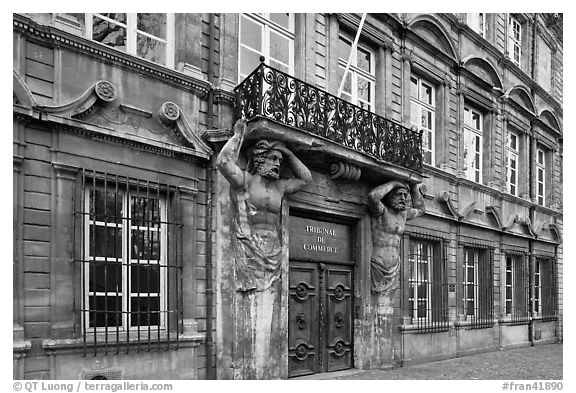Facade with sculptures supporting a balcony. Aix-en-Provence, France (black and white)