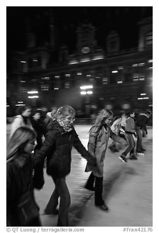 Girls skating by night, Hotel de Ville. Paris, France (black and white)