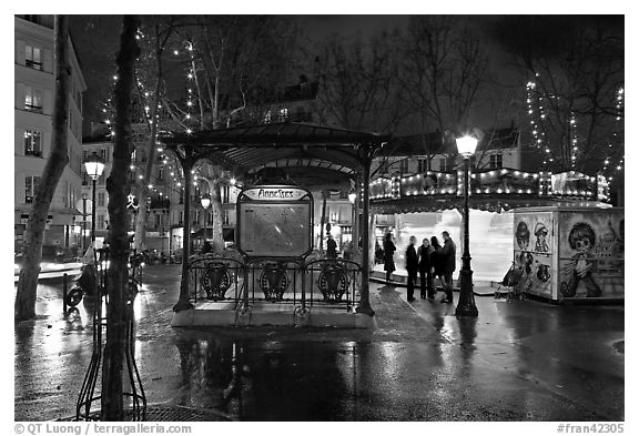 Square with subway entrance and carousel by night. Paris, France