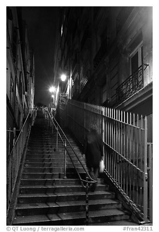 Woman climbing steep steps to the Butte, Montmartre. Paris, France