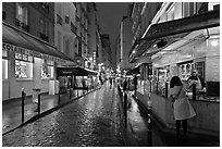 Woman buying food on street at night. Quartier Latin, Paris, France ( black and white)