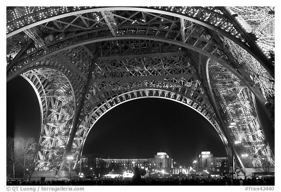 Palais de Chaillot seen through the base of Eiffel Tower by night. Paris, France