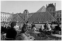 Cafe terrace in the Louvre main courtyard with glass pyramid. Paris, France (black and white)