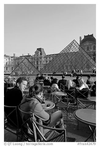 Couple sitting on terrace in Louvre main courtyard. Paris, France (black and white)