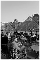 Couple sitting on terrace in Louvre main courtyard. Paris, France (black and white)