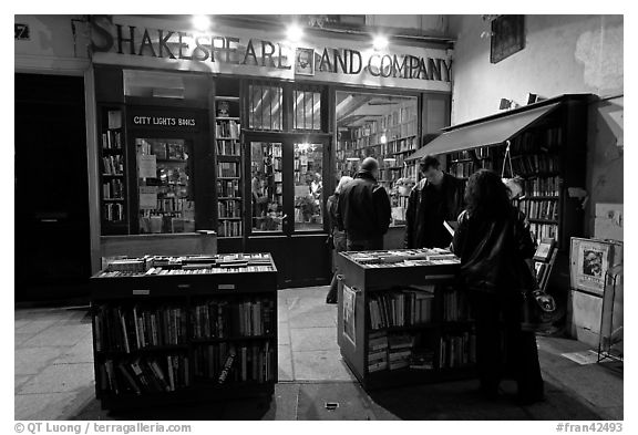 People reading in front of bookstore at night. Quartier Latin, Paris, France