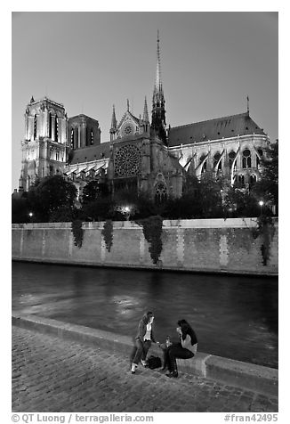 Two women having picnic across Notre Dame cathedral. Paris, France (black and white)
