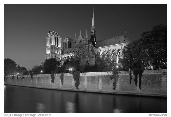 Side view of Notre Dame across Seine River at dusk. Paris, France