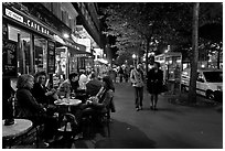 Cafe bar on sidewalk of a Grand Boulevard at night. Paris, France ( black and white)