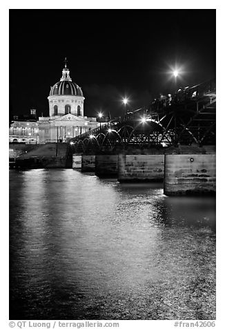 Institut de France and Pont des Arts reflected in Seine river at night. Paris, France