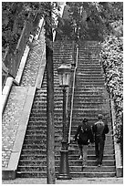 Couple walking up steet stairs, Montmartre. Paris, France (black and white)