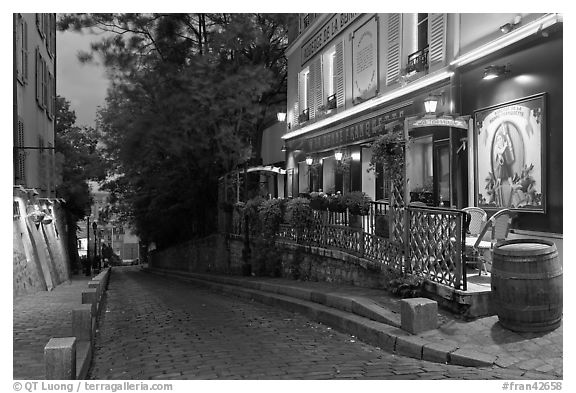 Cobblestone street and restaurant at dusk, Montmartre. Paris, France (black and white)