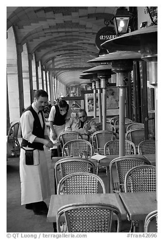 Waiters and customer, place des Vosges arcades. Paris, France (black and white)