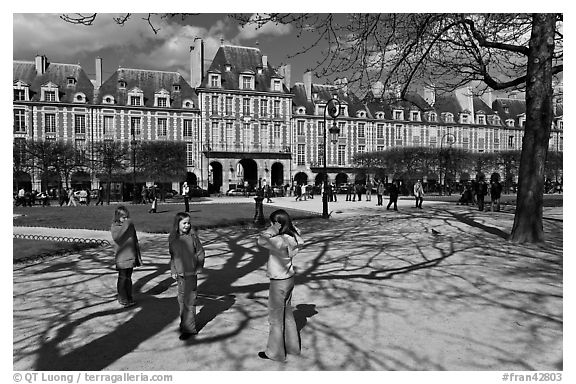 Girls playing in park, Place des Vosges. Paris, France