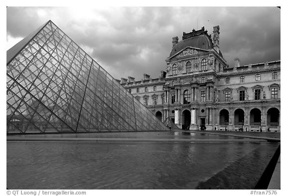 Pyramid and Richelieu wing of the Louvre under dark clouds. Paris, France (black and white)