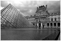 Pyramid and Richelieu wing of the Louvre under dark clouds. Paris, France (black and white)