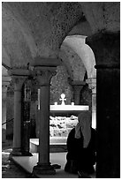 Nun in prayer in the Crypte of the Romanesque church of Vezelay. Burgundy, France (black and white)