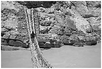Man crossing a river by rope bridge, Zanskar, Jammu and Kashmir. India ( black and white)