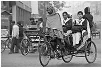Cycle-rickshaw carrying uniformed schoolgirls. New Delhi, India (black and white)