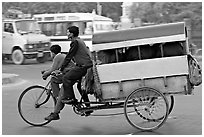 Cycle-rickshaw pulling a box for carrying schoolchildren. New Delhi, India (black and white)