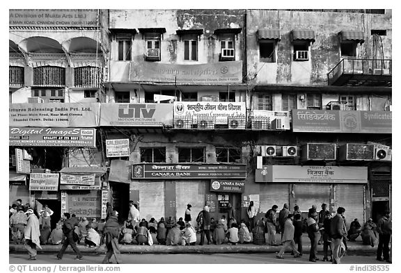 Street with many people waiting in front of closed stores, Old Delhi. New Delhi, India