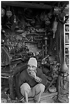 Man sitting in front of machine parts shop, Old Delhi. New Delhi, India ( black and white)