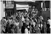 Street with women in colorful sari following wedding procession. Jodhpur, Rajasthan, India ( black and white)