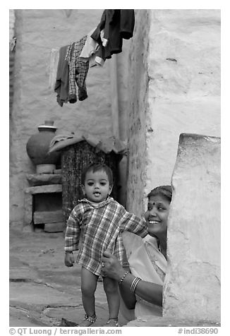 Baby girl and woman in blue alley. Jodhpur, Rajasthan, India (black and white)