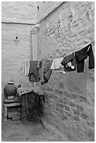 Laundry in alley with whitewashed walls tinted indigo. Jodhpur, Rajasthan, India (black and white)