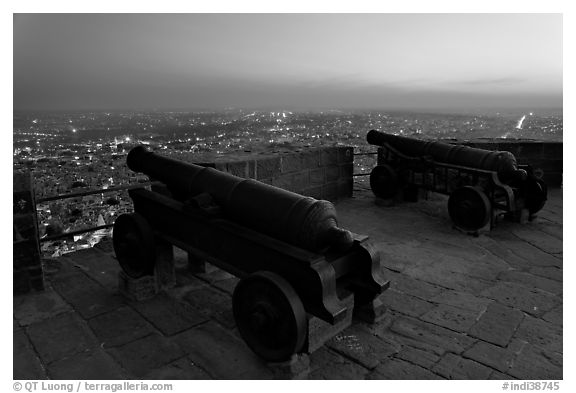 Cannons on top of Mehrangarh Fort, and city lights and dusk. Jodhpur, Rajasthan, India