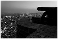 Cannon on top of Mehrangarh Fort, and city lights below. Jodhpur, Rajasthan, India ( black and white)