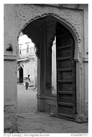 Archway with woman carrying water in courtyard. Jodhpur, Rajasthan, India (black and white)