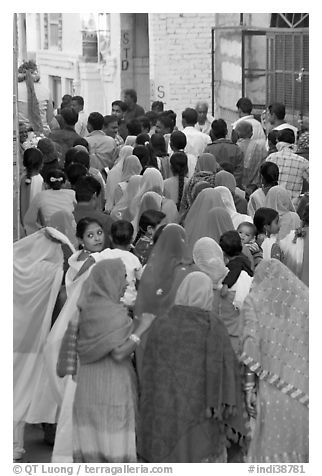 Narrow street filled by wedding procession. Jodhpur, Rajasthan, India (black and white)