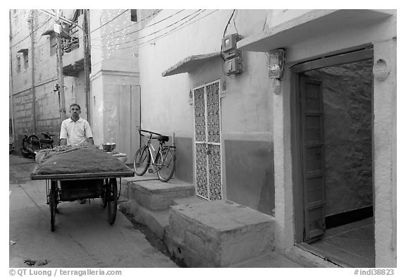 Man with vegetables car in front of painted house. Jodhpur, Rajasthan, India (black and white)